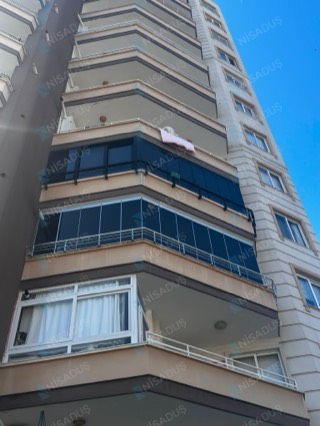 Yüksek binada iki balkonda koyu profilli cam balkon, Mersin
